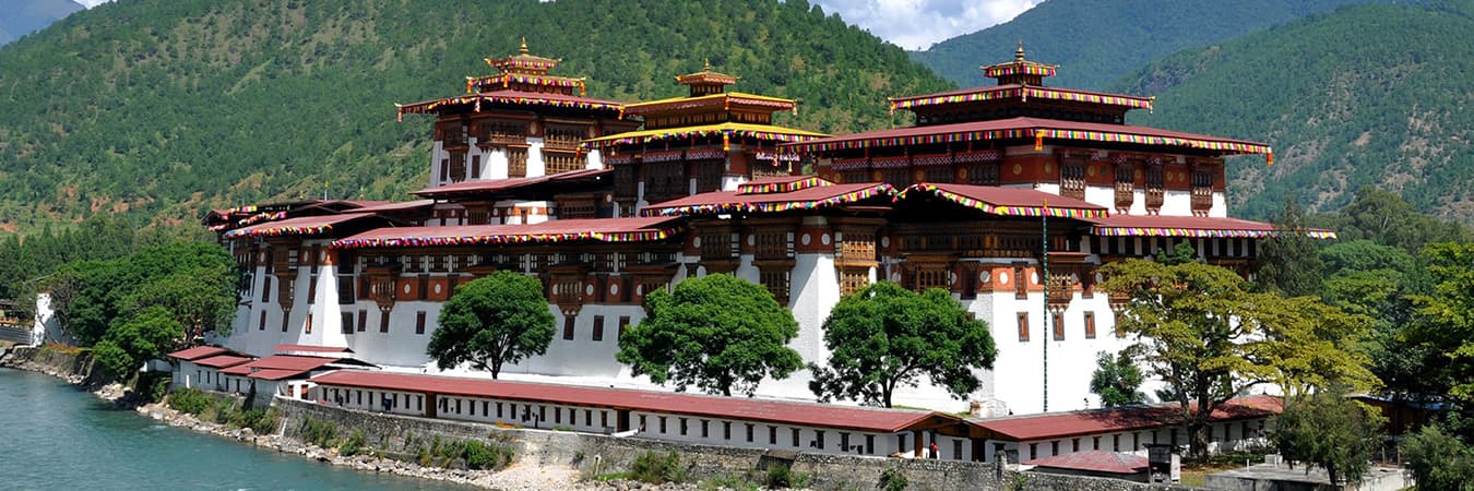 Punakha Dzong with white walls and tiered golden roofs beside a river in Bhutan