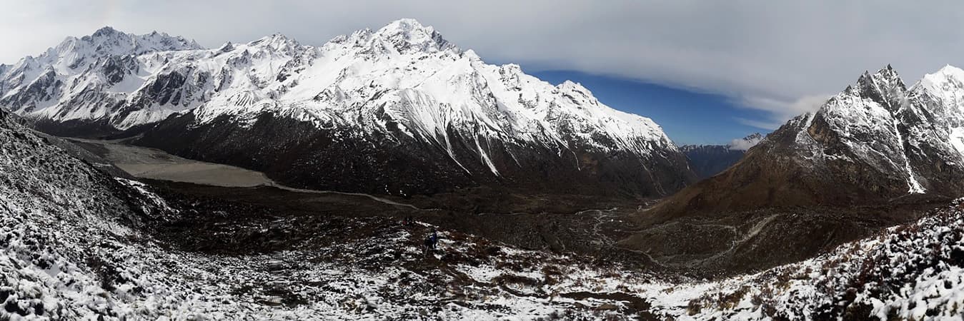 Snow-dusted valley floor beneath steep white peaks in the Langtang region