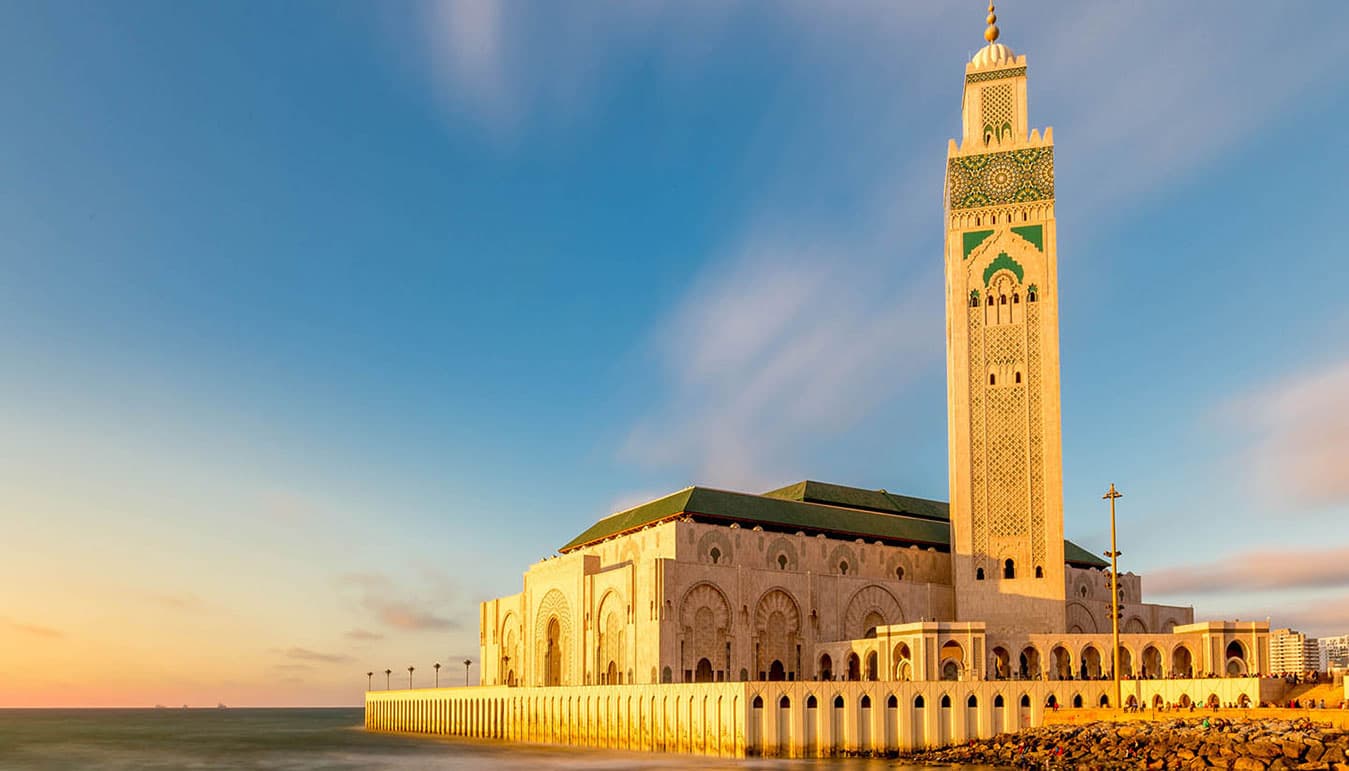 Hassan II Mosque and its tall minaret beside the sea in Casablanca at sunset